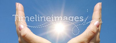 Female hands touching the Sun