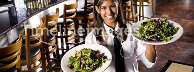 Hispanic waitress serving salads