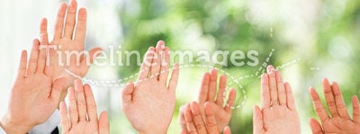 People raise their hands up over green background