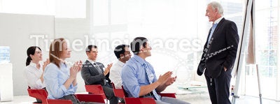 Cheerful business people clapping at a conference