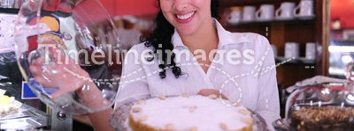 Owner of a cafe showing a cake