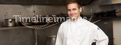 Chef Standing Next To Cooker In Kitchen