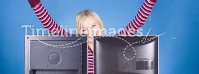 Happy young blonde woman at the two computer's screens