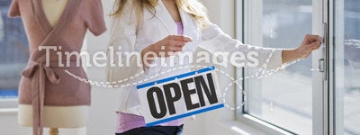 Shopkeeper holding open sign