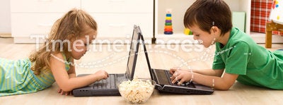 Kids with laptops and a bowl of popcorn