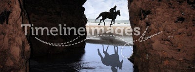 Horse galloping past cave