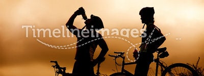 Mountain bike couple drinking in silhouette