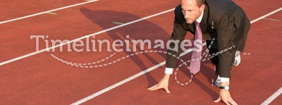 Business man on a running track ready to run