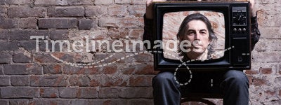 A man holding a retro television