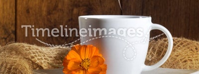Cup of coffee with orange flowers