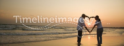 Couple on beach at sunset.