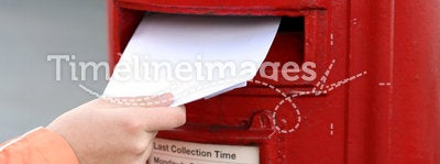Posting letter to red british postbox