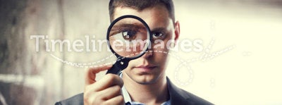 Detective looking through magnifying glass