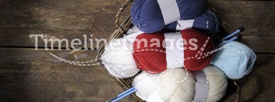 Basket with knitting wool on an old wooden floor