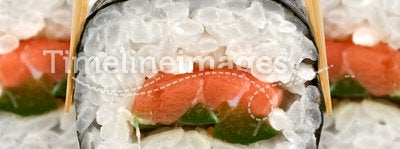 Sushi roll with chopsticks on white