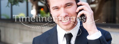 Portrait of handsome businessman using cell phone