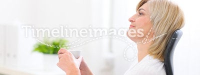 Dreaming senior business woman with cup