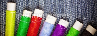 Sewing thread reels on blue denim