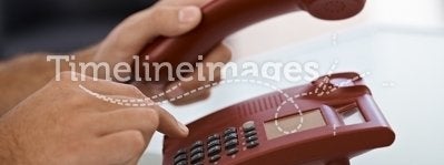 Male hand dial on landline phone