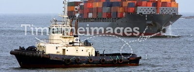 Container cargo ship with ocean tug