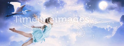 Little girl flying into the blue night sky