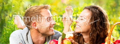 Couple Relaxing on the Grass and Eating Apples