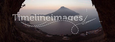 Silhouette of a rock climber on a cliff against picturesque view of Telendos Island at sunset