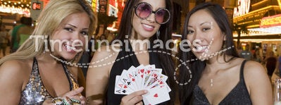 Women Holding Casino Chips, Playing Cards And Champagne Bottle