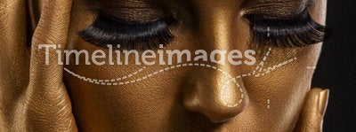 Gilt. Golden Woman's Face Closeup. Futuristic Giled Make-up. Painted Skin