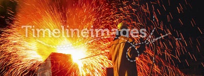 Industrial worker causing shower of sparks back view