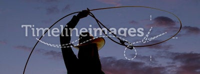 Silhouette western woman twirl rope