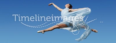 Dancer jumping against blue sk