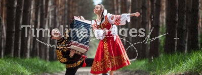 Couple dancing in russian traditional dress on nature