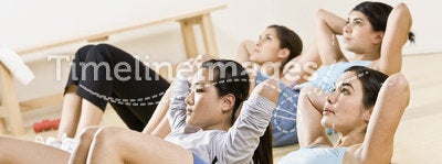 Young Women doing sit-ups in exercise class