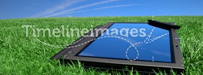 Tablet PC on green grass