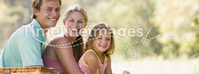 Family at park having a picnic and smiling