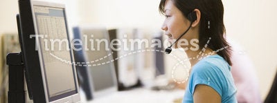 Woman wearing headset in computer room