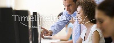 Man assisting woman in computer room
