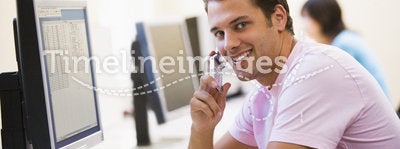 Man sitting in computer room using phone