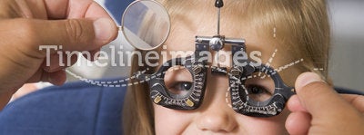 Optometrist in exam room with young girl