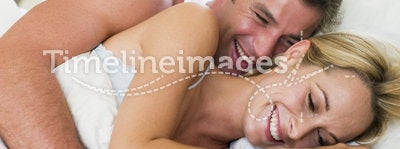 Couple lying in bed laughing