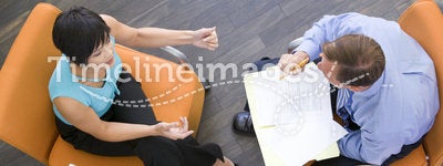 Two businesspeople sitting indoors having meeting