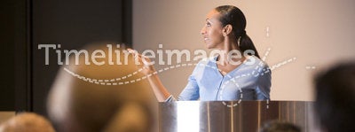 Businesswoman giving presentation at podium