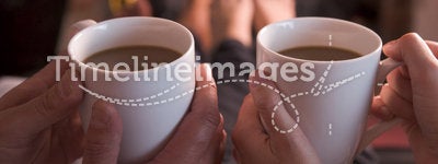 Feet warming at fireplace with coffee