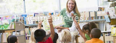 Teacher reading to children in library