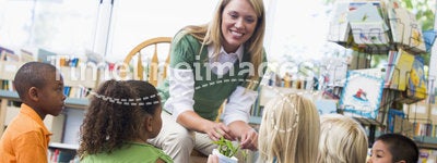 Teacher and children looking at seedling