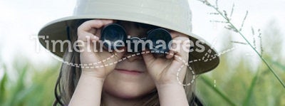 Young child searching with safari hat and binocula