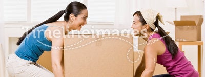 Women moving into new home and carrying box