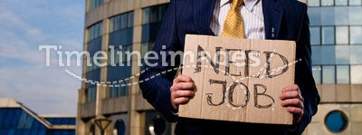 Young businessman holding sign Need Job outdoors