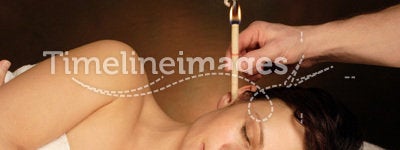 Woman with ear candle therapy